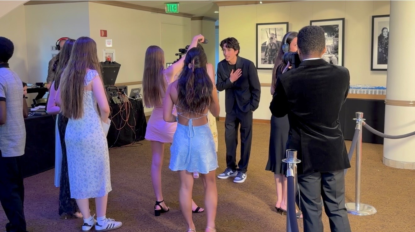 Hudson Hillin talking with guests in a theatre lobby before a screening